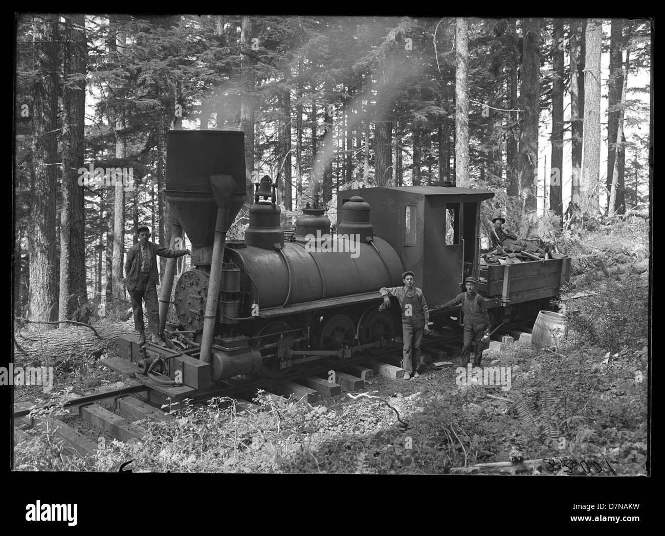 Die Peggy-Dampfmaschine, die bei Holzfällern in Oregon eingesetzt wurde, war Teil einer Expedition des frühen 20. Jahrhunderts. Der von Huron H. Smith entworfene Motor half den Holzfällern und war ein Schlüsselstück in der Holzindustrie. Dieses Foto aus dem Jahr 1910-1911 zeigt den eingesetzten Motor und markiert einen bedeutenden Fortschritt in der Dampflokomotivtechnologie für industrielle Zwecke. Stockfoto