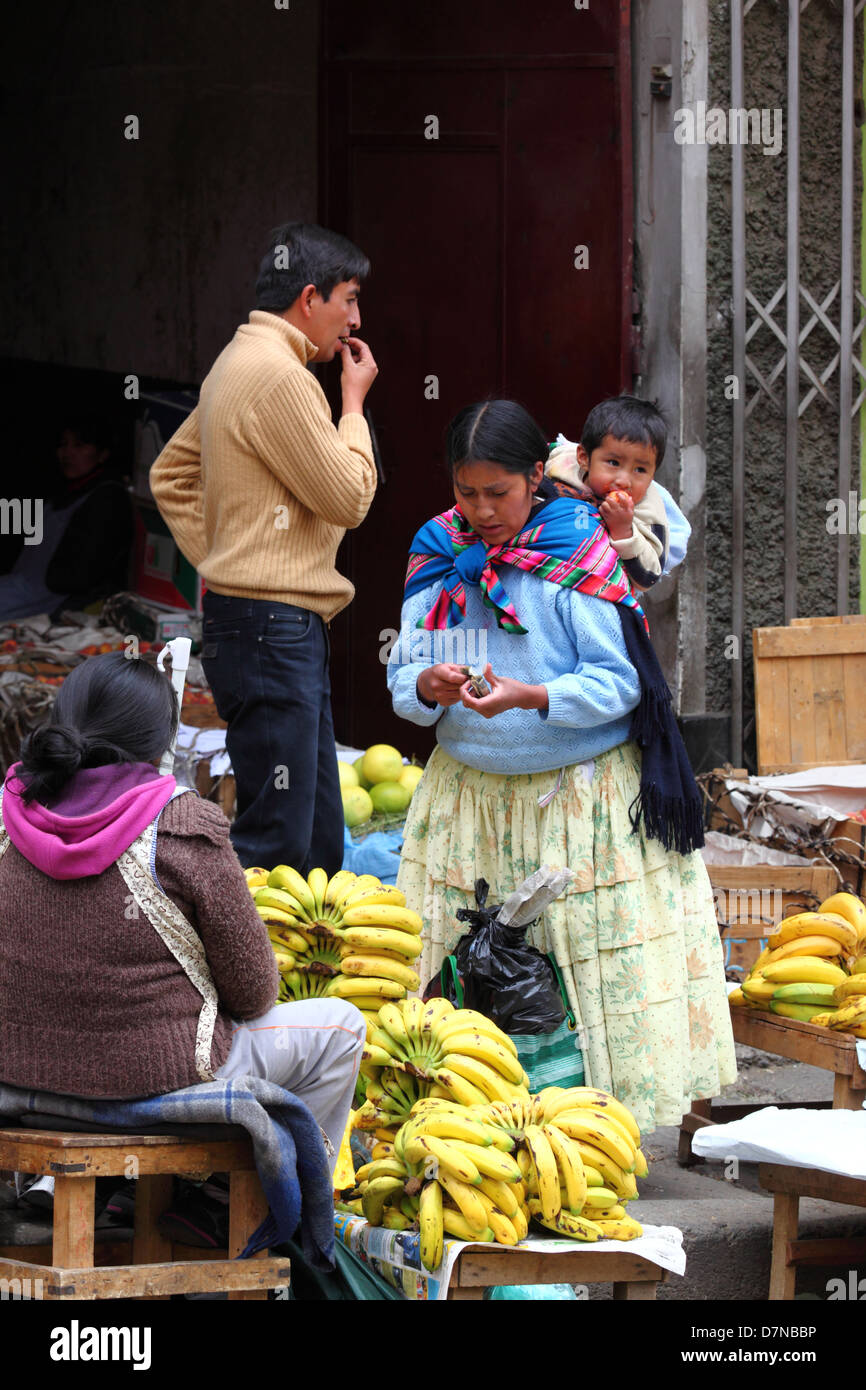 Amara Dame oder Cholita kauft Obst im Mercado Rodriguez, einem typischen Straßenmarkt in der Nähe des Stadtzentrums, La Paz, Bolivien Stockfoto