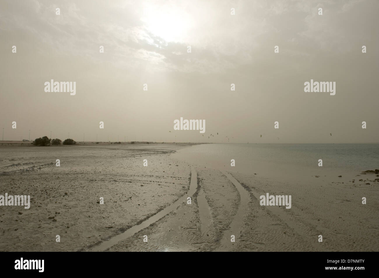 Plötzlichen Sandsturm über eine Abu Dhabi Beach die Sonne beflecken und fangen entfernten Kite-Surfer entwickelt Stockfoto