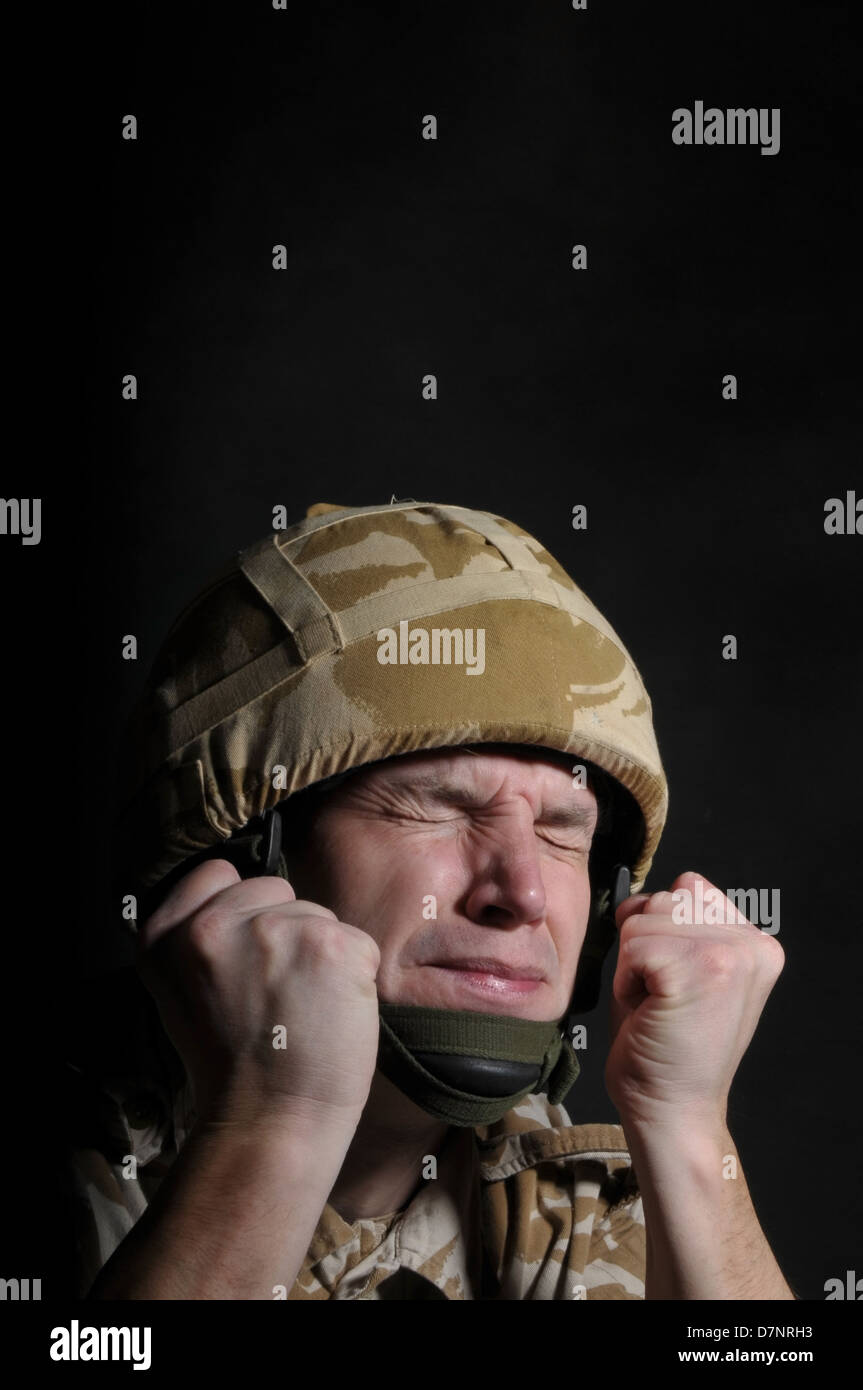 Britischer Soldat leiden Kriegszittern/PTSD, vor einem schwarzen Hintergrund. Stockfoto