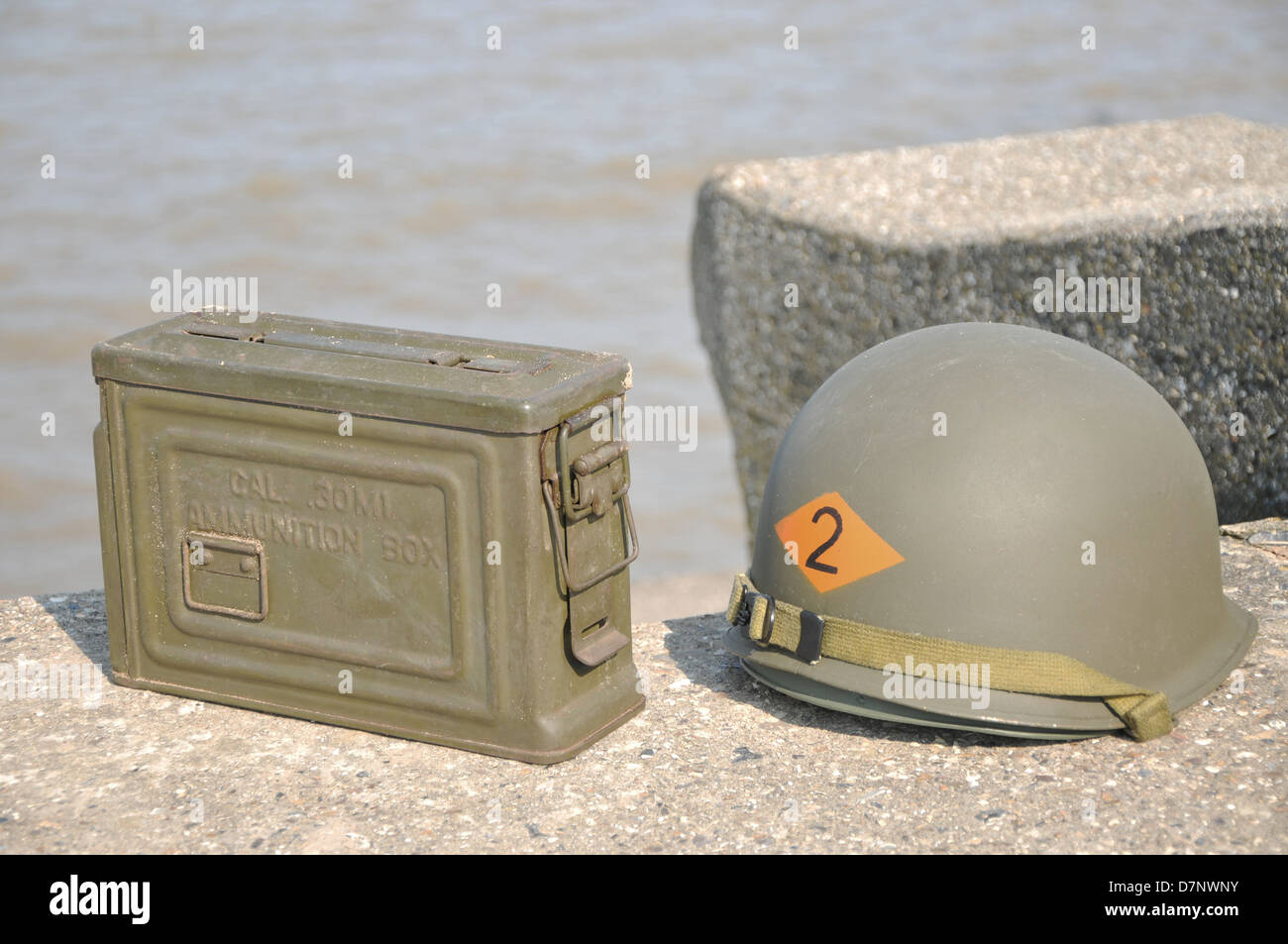 WW2 American Helm und Munition Kasten ruht auf Betonbunker mit dem Meer im Hintergrund. Stockfoto