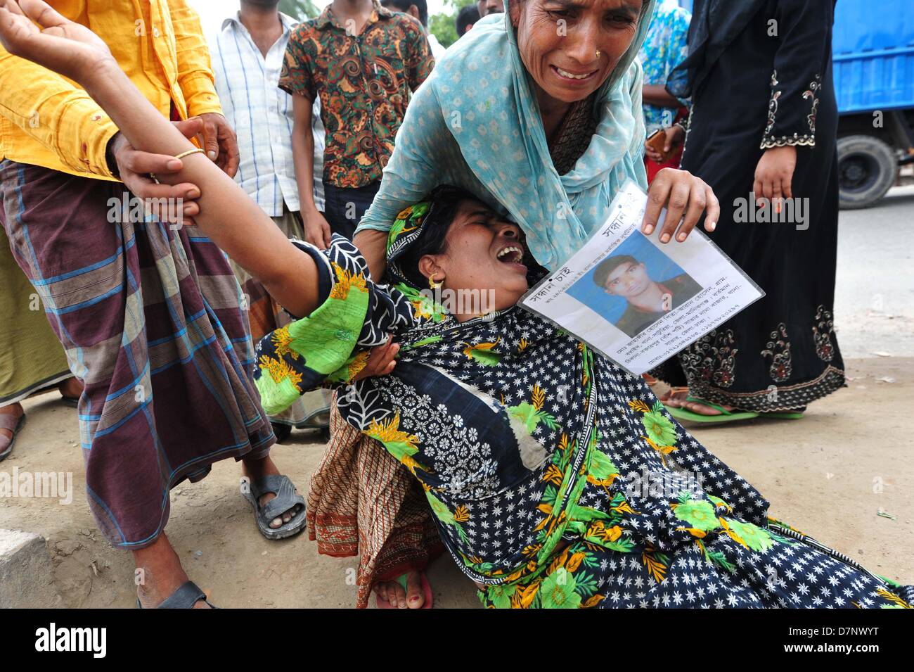 Savar, Bangladesch. 11. Mai 2013. Ein Bangladeshi Familienmitglied Schreie, als sie oben hält das Porträt ihres fehlenden relative, geglaubt, in den Trümmern einer 8-stöckigen Gebäude Einsturz in Savar gefangen zu sein, in der Nähe von Dhaka. Die behandelnden Ärzte ein 'Wunder' Überlebenden zogen von den Ruinen einer eingestürzten Gebäude nach 17 Tagen sagte, dass sie Tat 'große' und hatte mit ihrer Familie wieder vereint. Reshma, 18, eine Näherin gegraben aus aus dem Schutt der Textilfabrik komplex", gab nie auf Hoffnung", aus den Trümmern gerettet werden würde. Stockfoto