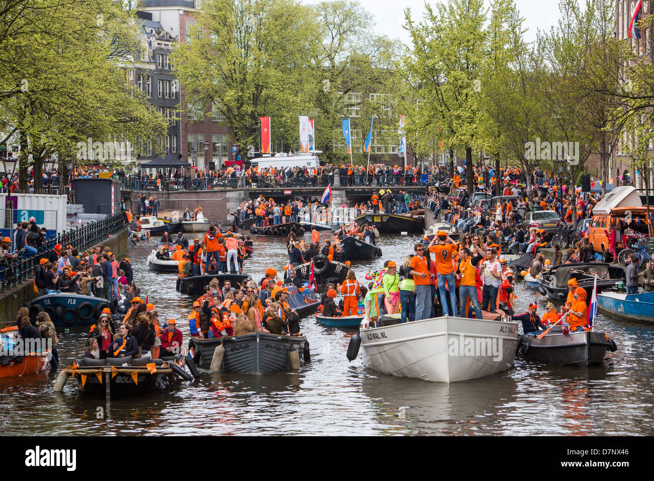 Jährlichen Königinnentag in den Niederlanden. Bootskorso in den Grachten von Amsterdam, Altstadt. Menschen in Orange gekleidet. Amsterdam Stockfoto