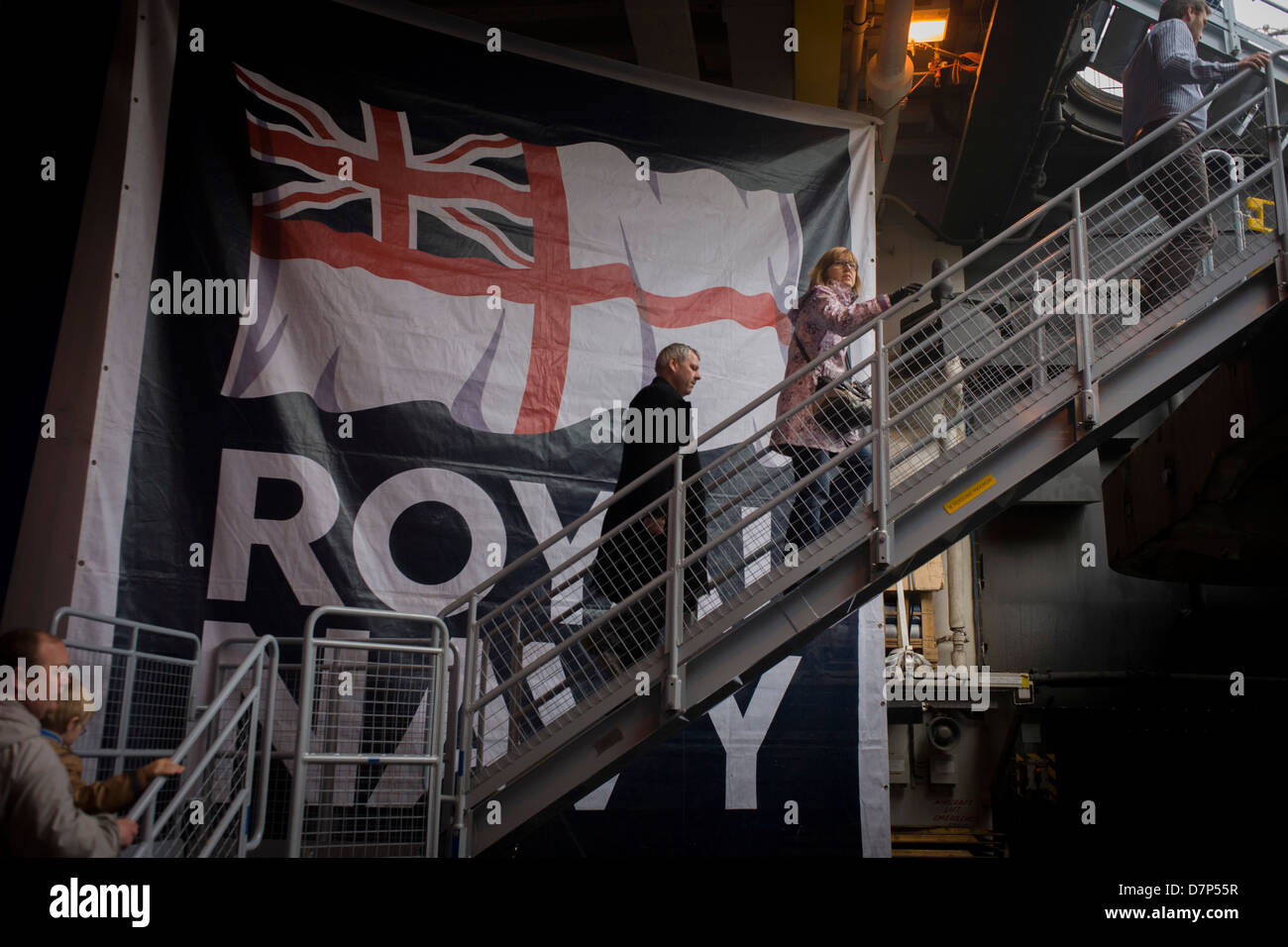 Besucher Treppen aus dem Hangardeck zum oberen Oberdeck während einer Tour durch dem Hangardeck an Bord Flugzeugträger der Royal Navy HMS Illustrious während eines öffentlichen Open-Tages in Greenwich. Illustrious angedockt an der Themse, so dass die Steuern zahlenden öffentlichen um den Decks vor seiner bevorstehenden Decommisioning zu erkunden. Navy Personal half mit dem PR-Event über die Mai Wochenende, historisch der Heimat England Flotte. Stockfoto