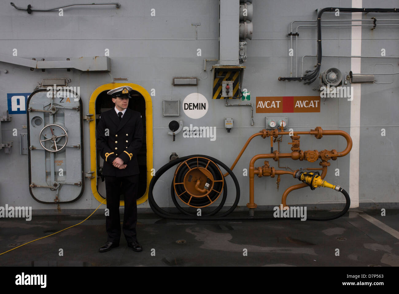 Ein Student Offizier vom Dienst auf der oberen deck während einer Tour durch die breite Öffentlichkeit an Bord Flugzeugträger der Royal Navy HMS Illustrious während eines öffentlichen Open-Tages in Greenwich. Illustrious angedockt an der Themse, so dass die Steuern zahlenden öffentlichen um den Decks vor seiner bevorstehenden Decommisioning zu erkunden. Navy Personal half mit dem PR-Event über die Mai Wochenende, historisch der Heimat England Flotte. Stockfoto