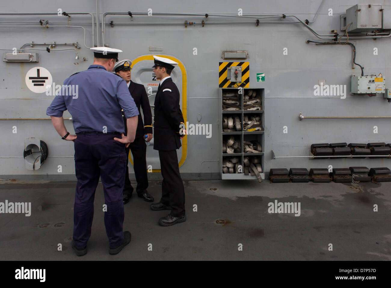 Student Offiziere und eine Bewertung im Einsatz auf der Oberseite deck während einer Tour durch die breite Öffentlichkeit an Bord Flugzeugträger der Royal Navy HMS Illustrious während eines öffentlichen Open-Tages in Greenwich. Illustrious angedockt an der Themse, so dass die Steuern zahlenden öffentlichen um den Decks vor seiner bevorstehenden Decommisioning zu erkunden. Navy Personal half mit dem PR-Event über die Mai Wochenende, historisch der Heimat England Flotte. Stockfoto