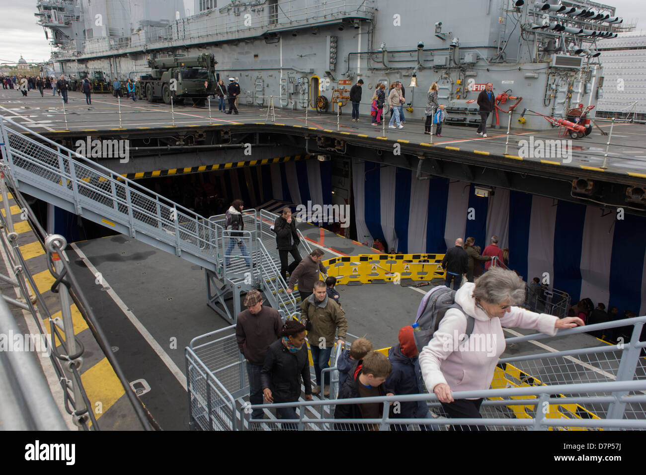 Besucher Treppen aus dem Hangardeck zum oberen Oberdeck während einer Tour durch dem Hangardeck an Bord Flugzeugträger der Royal Navy HMS Illustrious während eines öffentlichen Open-Tages in Greenwich. Illustrious angedockt an der Themse, so dass die Steuern zahlenden öffentlichen um den Decks vor seiner bevorstehenden Decommisioning zu erkunden. Navy Personal half mit dem PR-Event über die Mai Wochenende, historisch der Heimat England Flotte. Stockfoto