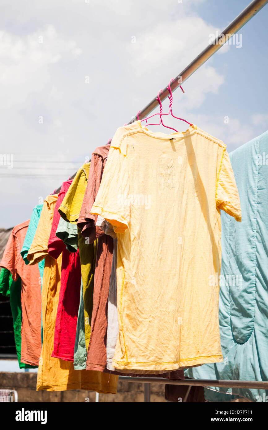 Bunte Kleidung trocknen auf der Wäscheleine unter Sonnenlicht Stockfoto
