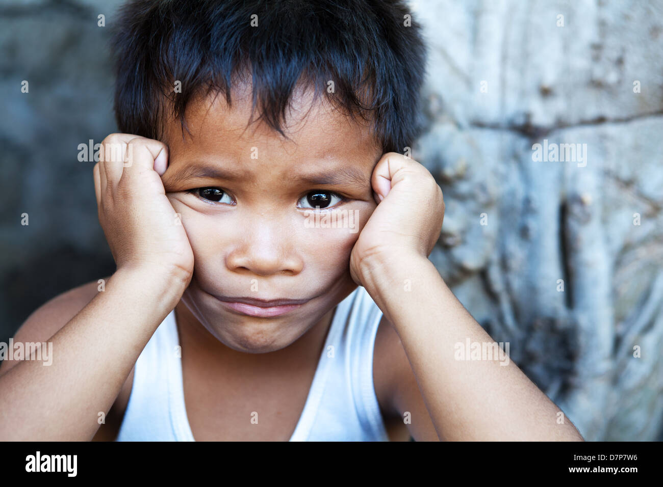 Young Asian männlich gegen Wand - Armut in den Philippinen Stockfoto