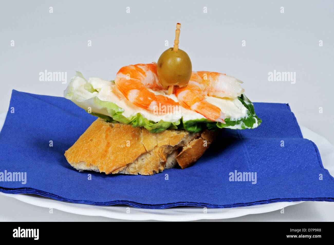 Kopfsalat mit Sahne Käse und Garnelen Tapa garniert mit grünen Oliven und serviert auf knusprigem Brot gefüllt. Stockfoto