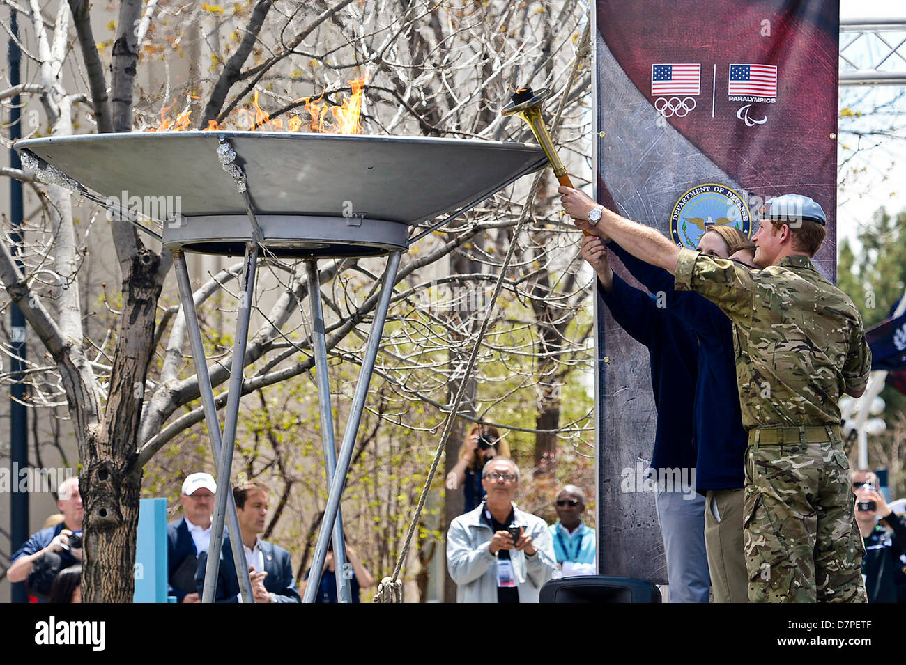 Paralympics-Goldmedaillen-Gewinner Navy Lieutenant Bradley Snyder, mit Hilfe von Prinz Harry und Olympiateilnehmer Missy Franklin, Licht der offiziellen Fackel, die 2013 Krieger Spiele bei den US Olympic Training Center in Colorado Springs, Colorado, 11. Mai 2013 beginnen. Vom 11 bis 16. Mai, mehr als 200 Verletzte, Kranke und verletzte Servicemembers und Veteranen aus der US-Marines, Armee, Luftwaffe und Marine sowie ein Team aus US Special Operations Command und ein internationales Team aus dem Vereinigten Königreich, kämpfen um das Gold in Leichtathletik, schießen, Schwimmen, Radfahren, Bogenschießen, whe Stockfoto