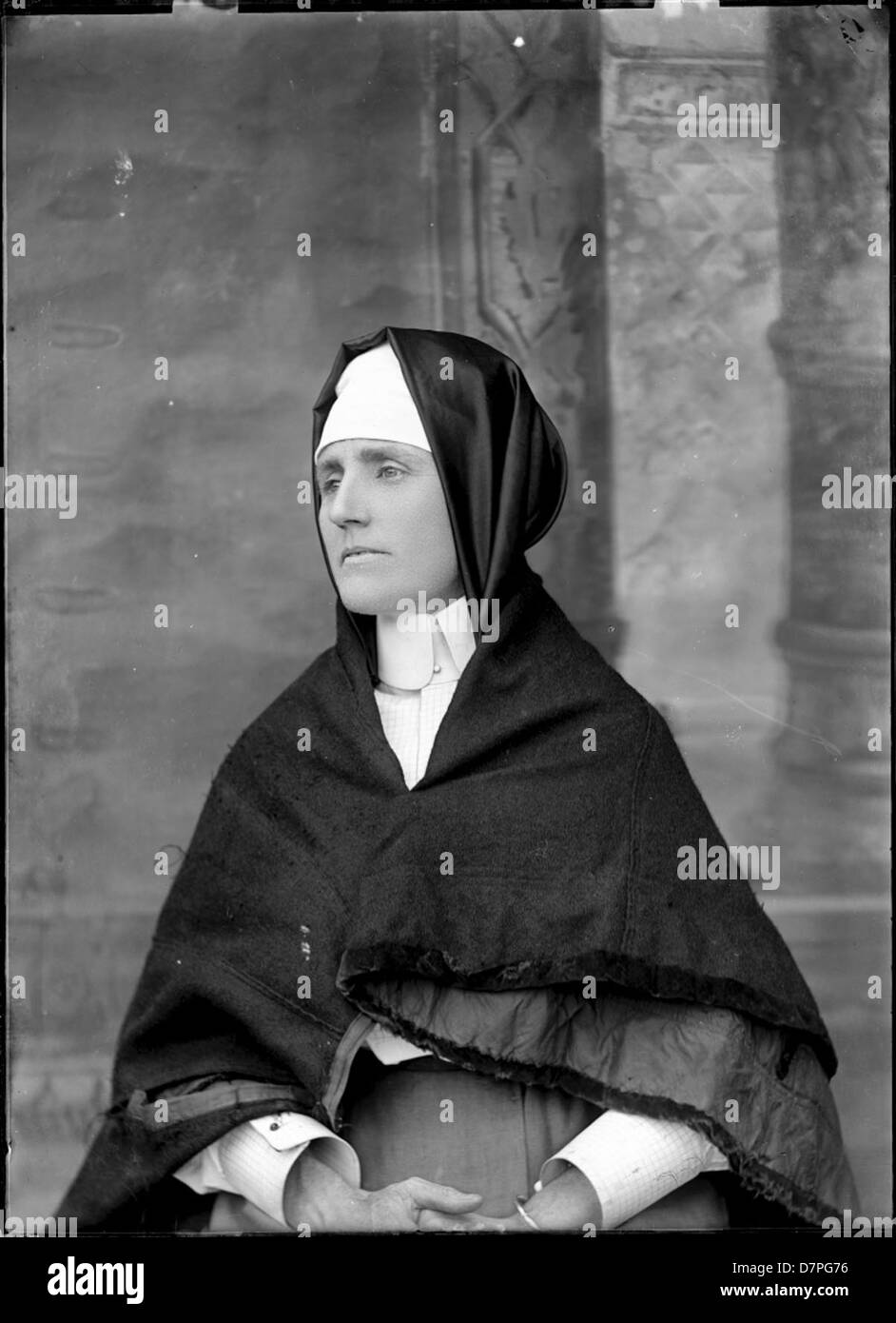 Dieses Porträt zeigt eine junge Frau in einem schicken Outfit, das die Modetrends der Zeit widerspiegelt. Ihre Kleidung besteht aus komplizierten Kragen und einem Schal, und ihre sitzende Haltung vermittelt sowohl Anmut als auch Ausgeglichenheit. Das Porträt ist ein Beispiel für die künstlerische Darstellung von Frauen in historischen Zusammenhängen. Stockfoto