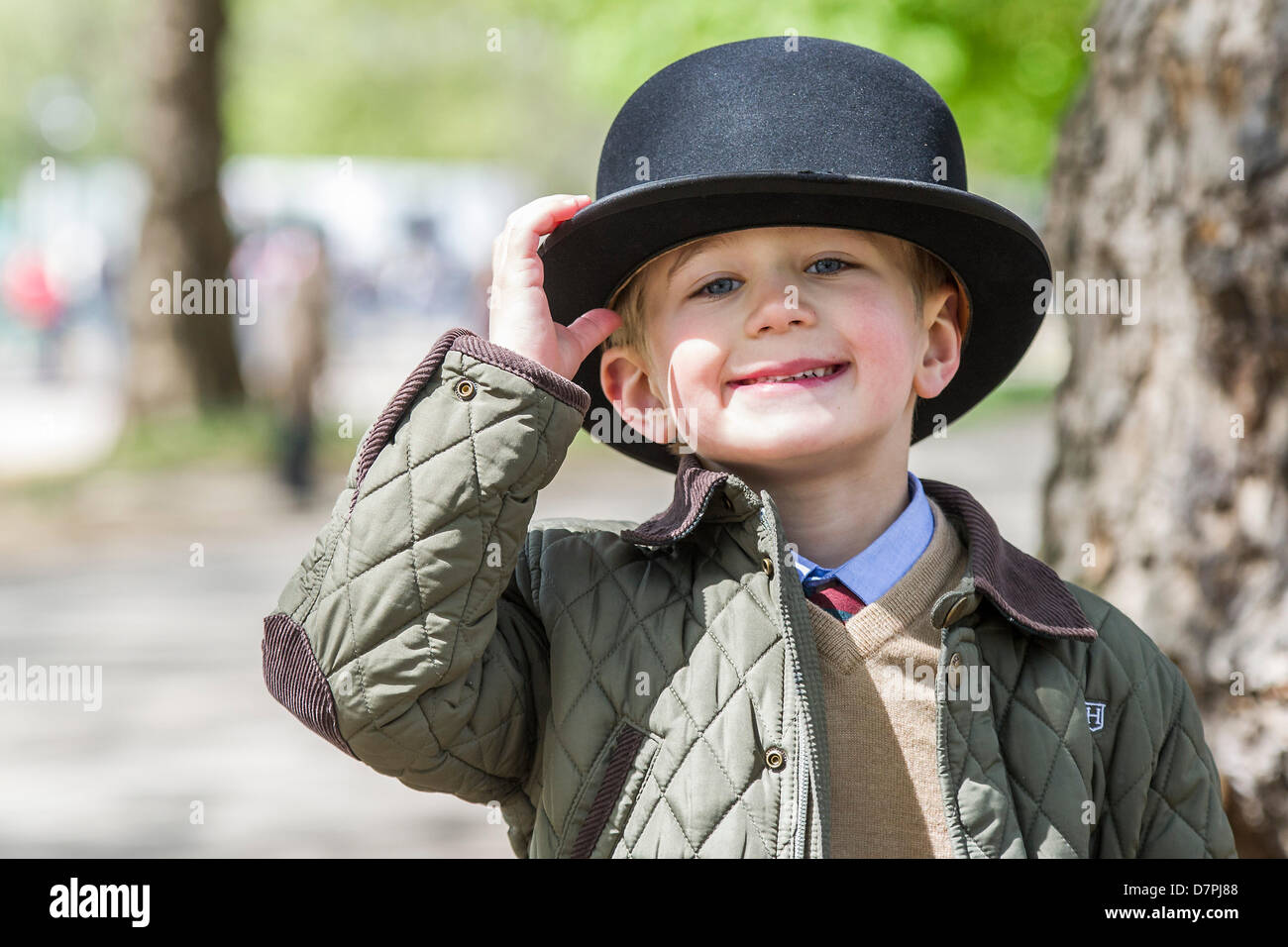 Hyde Park, London, UK 12 Mai 2013. Ein Junge erfreut sich eines der Kegler für Größe anprobieren. Ihre Königliche Hoheit The Princess Royal KG, KT, GCVO, Oberst Chef des Königs Royal Hussars nimmt den Gruß und legt einen Kranz an der jährlichen Parade und Service im kombiniert Kavallerie alte Kameraden Verband in der Kavallerie-Gedenkstätte. Offiziere tragen Bowler-Hüte und Anzüge sind von allen aber die Bands statt Uniform getragen.  5-Band führte marschierende Abteilungen der Kavallerie und Yeomanry Regiments Verbände und aus dem 2. Weltkrieg bis hin zu Irak und Afghanistan-Veteranen. Staatliche Trompeter der Haushalt CavalryG Stockfoto