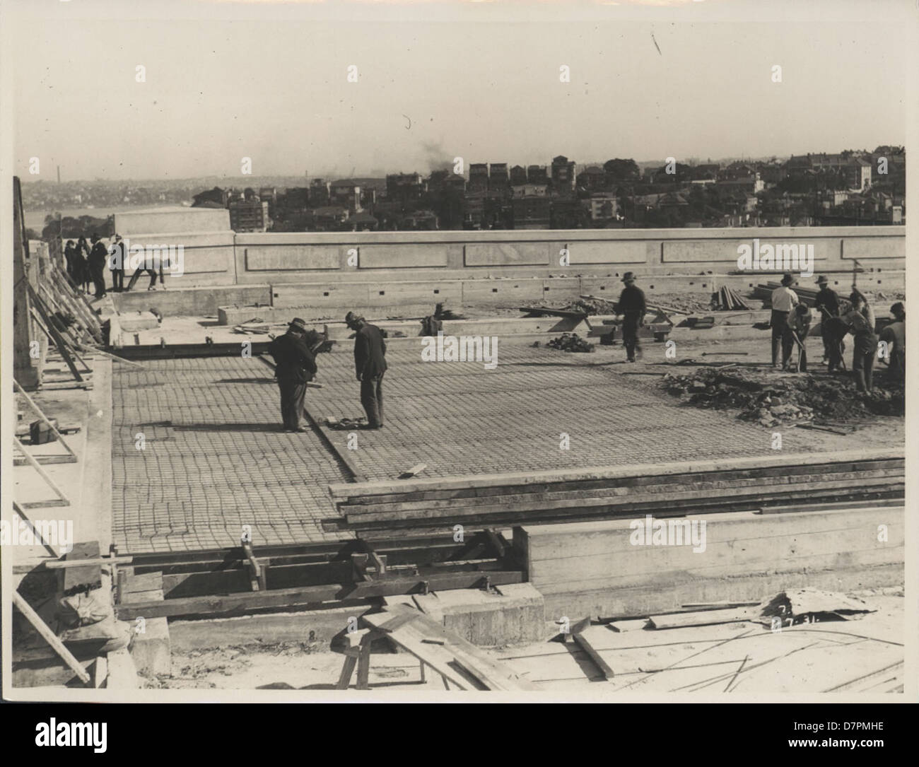 Dieser Fotodruck aus dem Jahr 1931 erfasst die Verlegung der Fahrbahnoberfläche auf der Sydney Harbour Bridge, ein wichtiger Moment bei der Konstruktion. Das Foto, das vom New South Wales Department of Public Works aufgenommen wurde, dokumentiert diese legendäre technische Leistung. Stockfoto Dieser Fotodruck aus dem Jahr 1931 erfasst die Verlegung der Fahrbahnoberfläche auf der Sydney Harbour Bridge, ein wichtiger Moment bei der Konstruktion. Das Foto, das vom New South Wales Department of Public Works aufgenommen wurde, dokumentiert diese legendäre technische Leistung. Stockfoto