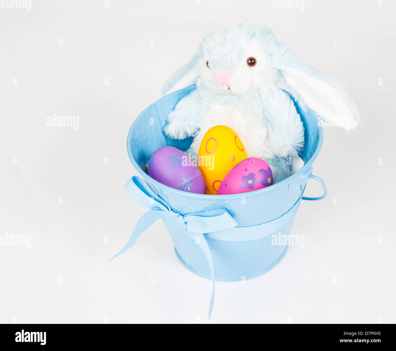 Ostern-Eimer gefüllt mit Spielzeug, Eiern und Süßigkeiten. Isoliert auf weißem Hintergrund. Stockfoto