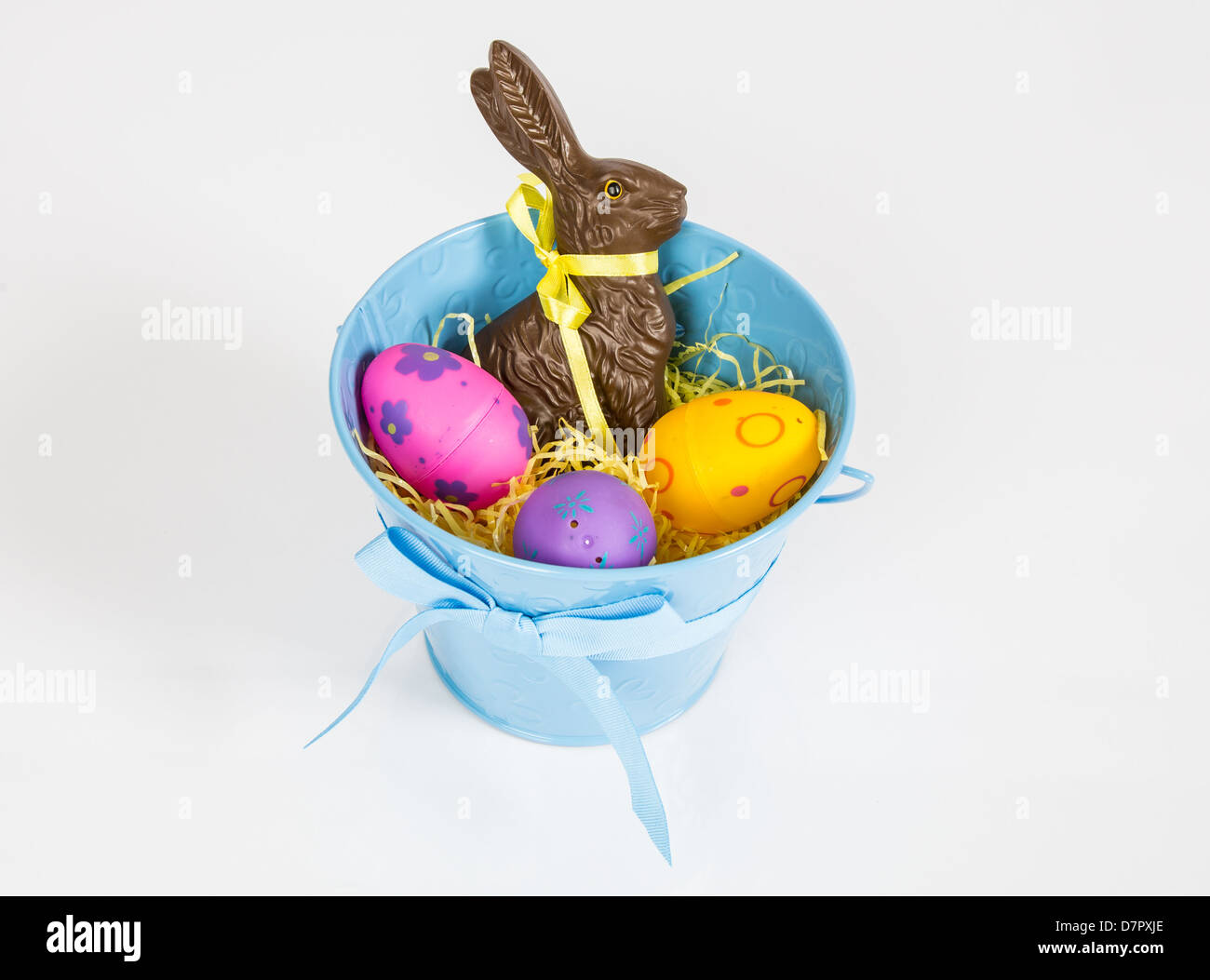 Ostern-Eimer gefüllt mit Spielzeug, Eiern und Süßigkeiten. Isoliert auf weißem Hintergrund. Stockfoto