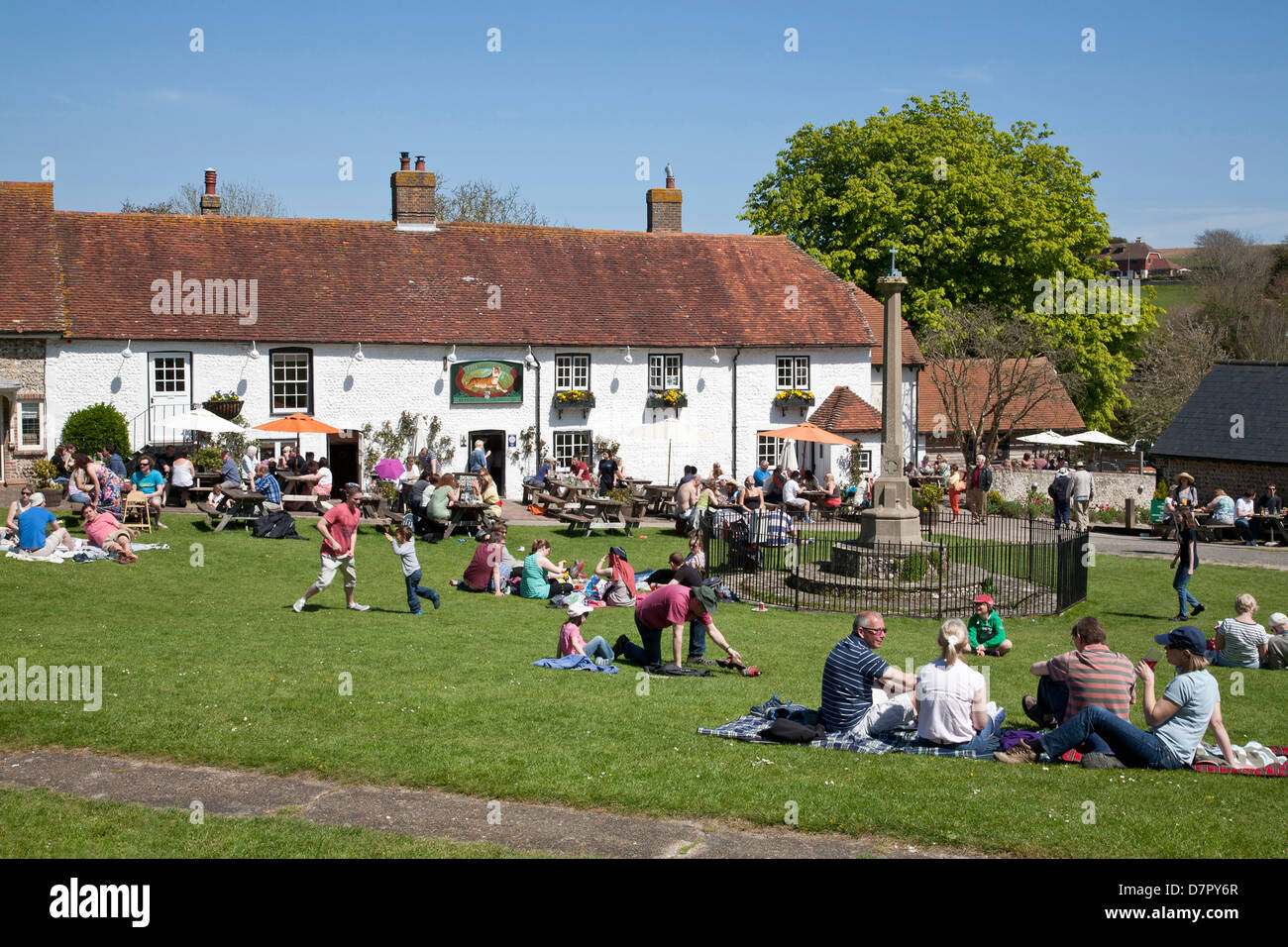 Englisch Dorfkneipe der Tiger im Osten Dean, East Sussex. Beschäftigt an einem Feiertag Montag Ppl sitzen auf dem Grün und die Sonne genießen. Stockfoto