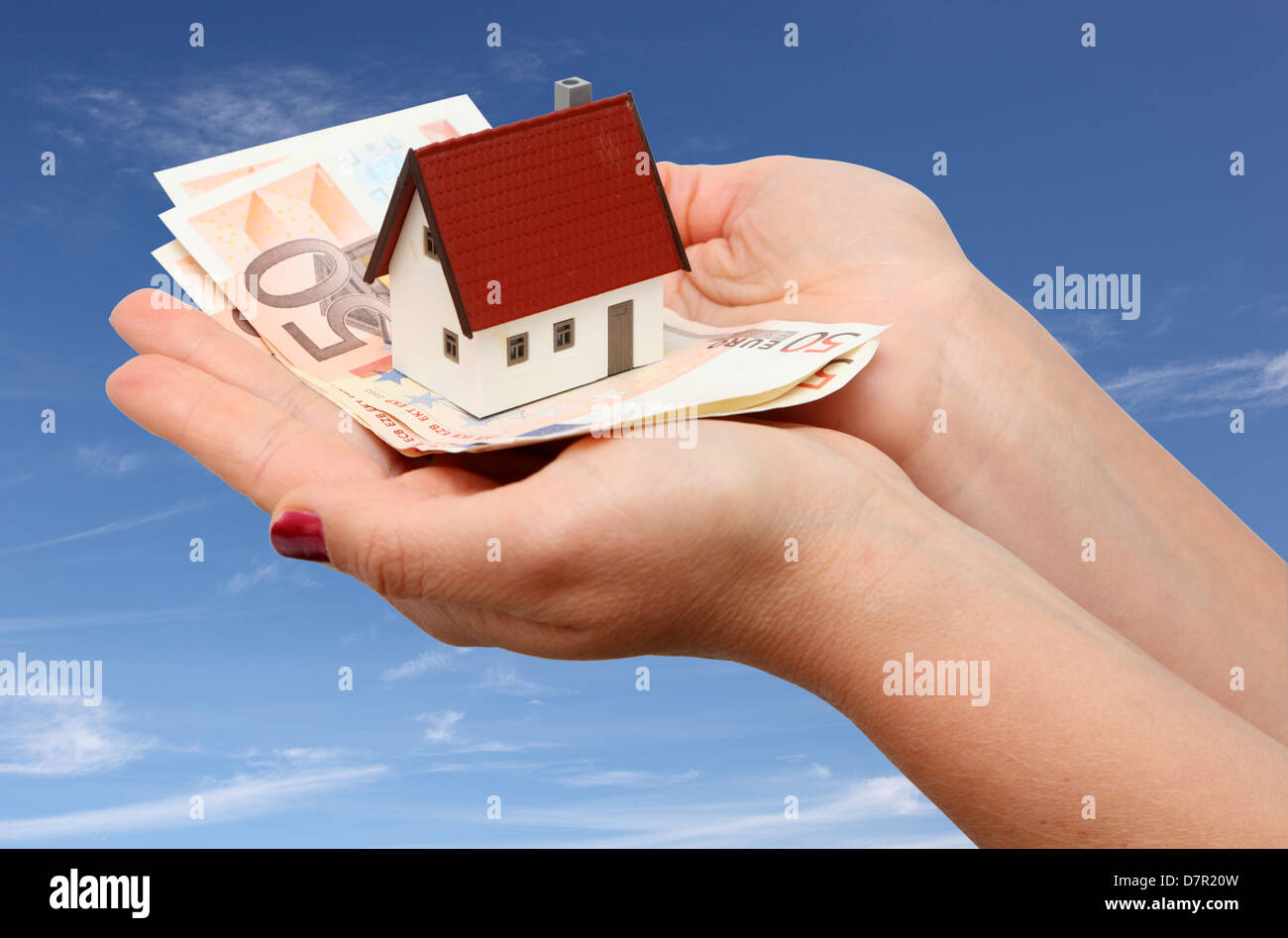 Neues Haus und Geld über Himmelshintergrund Stockfoto