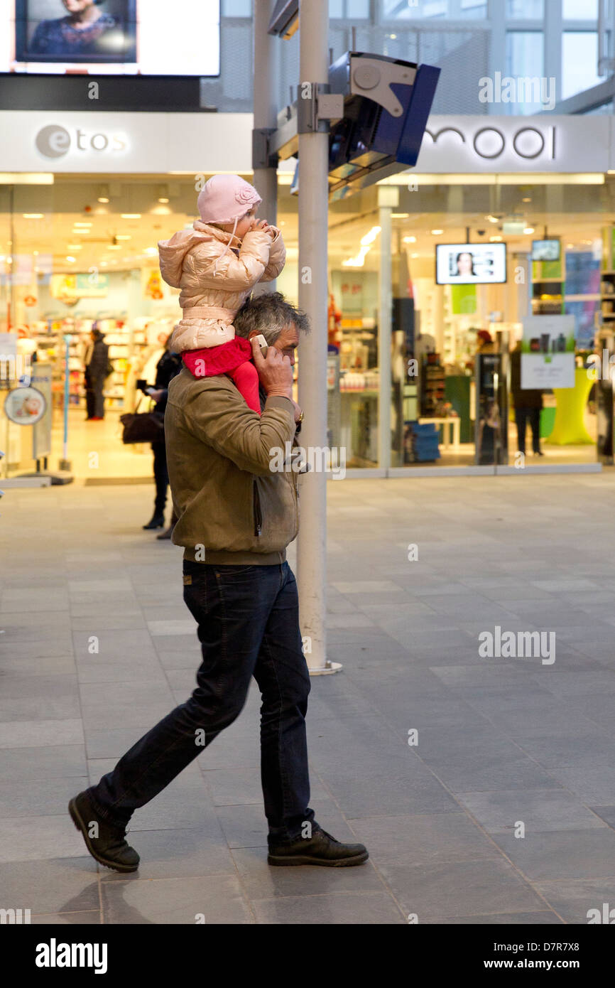 Der Mensch am Telefon Kleinkind auf den Schultern Stockfoto