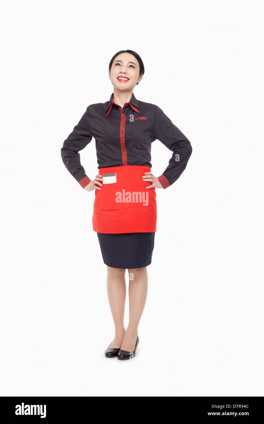 Junge Kellnerin, die hand auf den Hüften, Studio gedreht Stockfoto