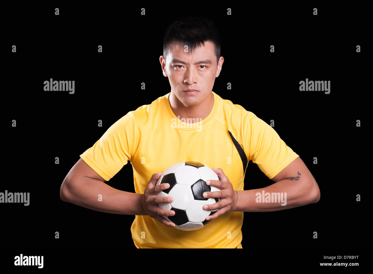 Fußballer-Spieler mit Ball, Brust, schwarzer Hintergrund Stockfoto