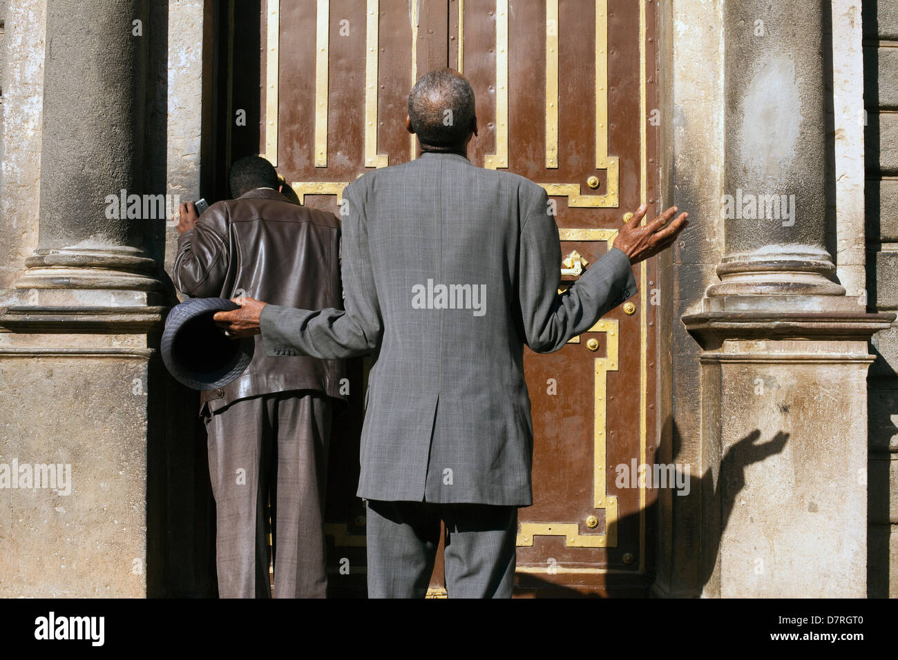 Männer, die Anbetung außerhalb Str. Georges Kathedrale in Addis Ababa, Äthiopien Stockfoto