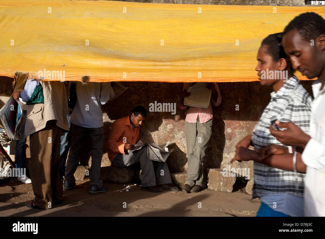 Männer lesen gemietet Zeitungen auf der Straße in Addis Abeba, Äthiopien. Stockfoto