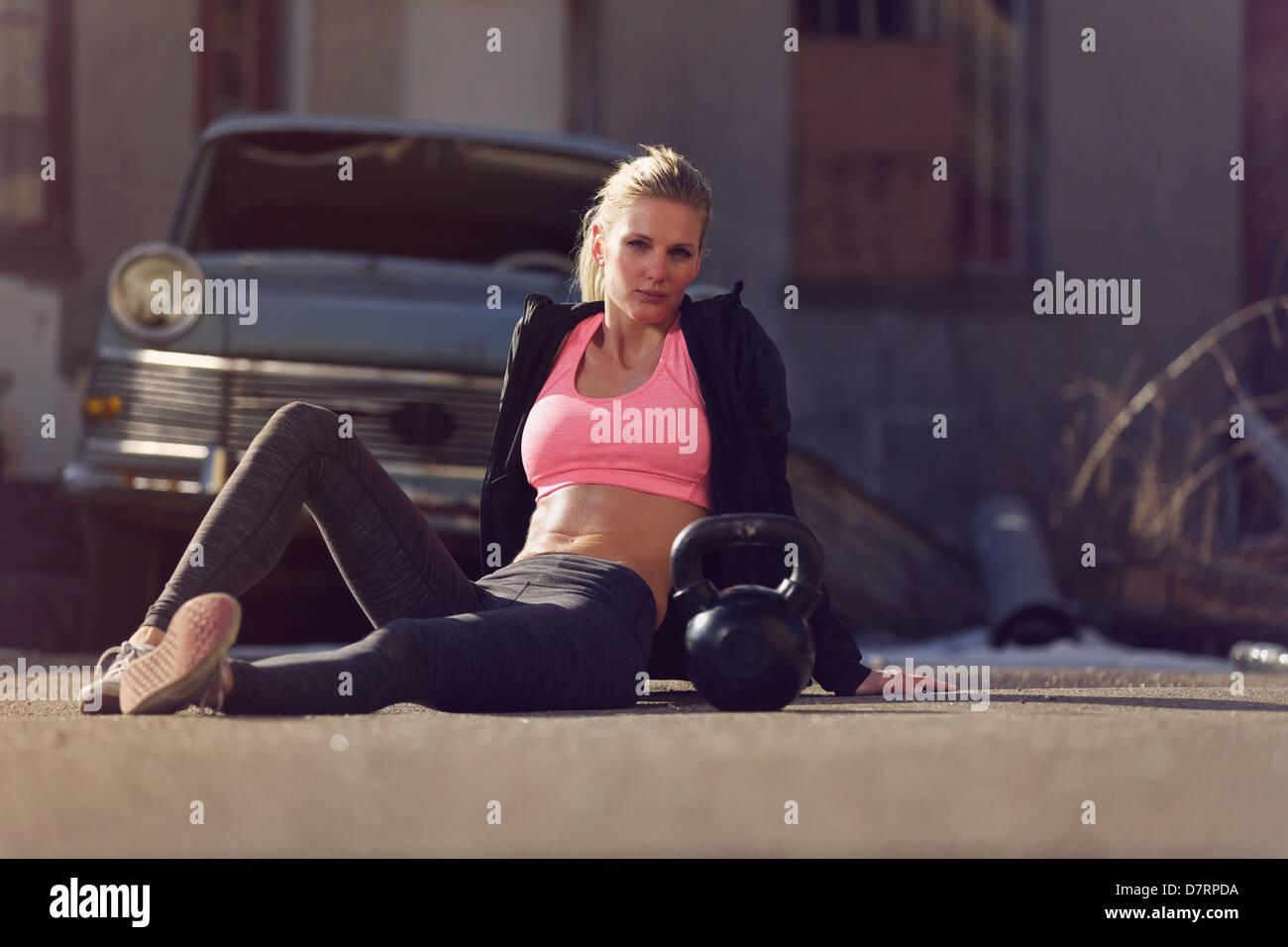 Porträt einer Crossfit Frau sitzt auf der Straße nach ihrem Training Stockfoto