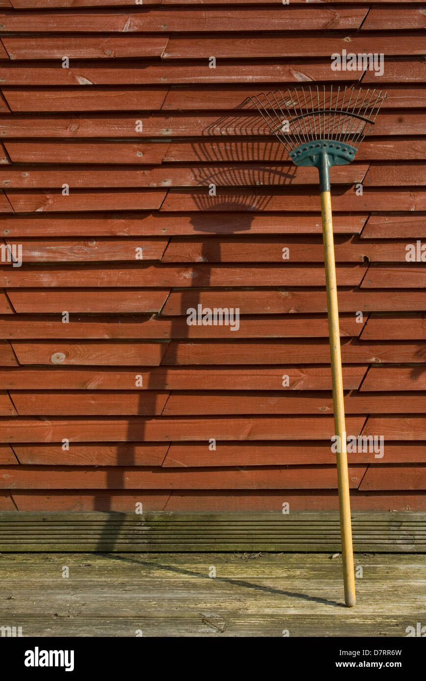 Rechen Gartenwerkzeug stützte sich auf Zaun Stockfoto