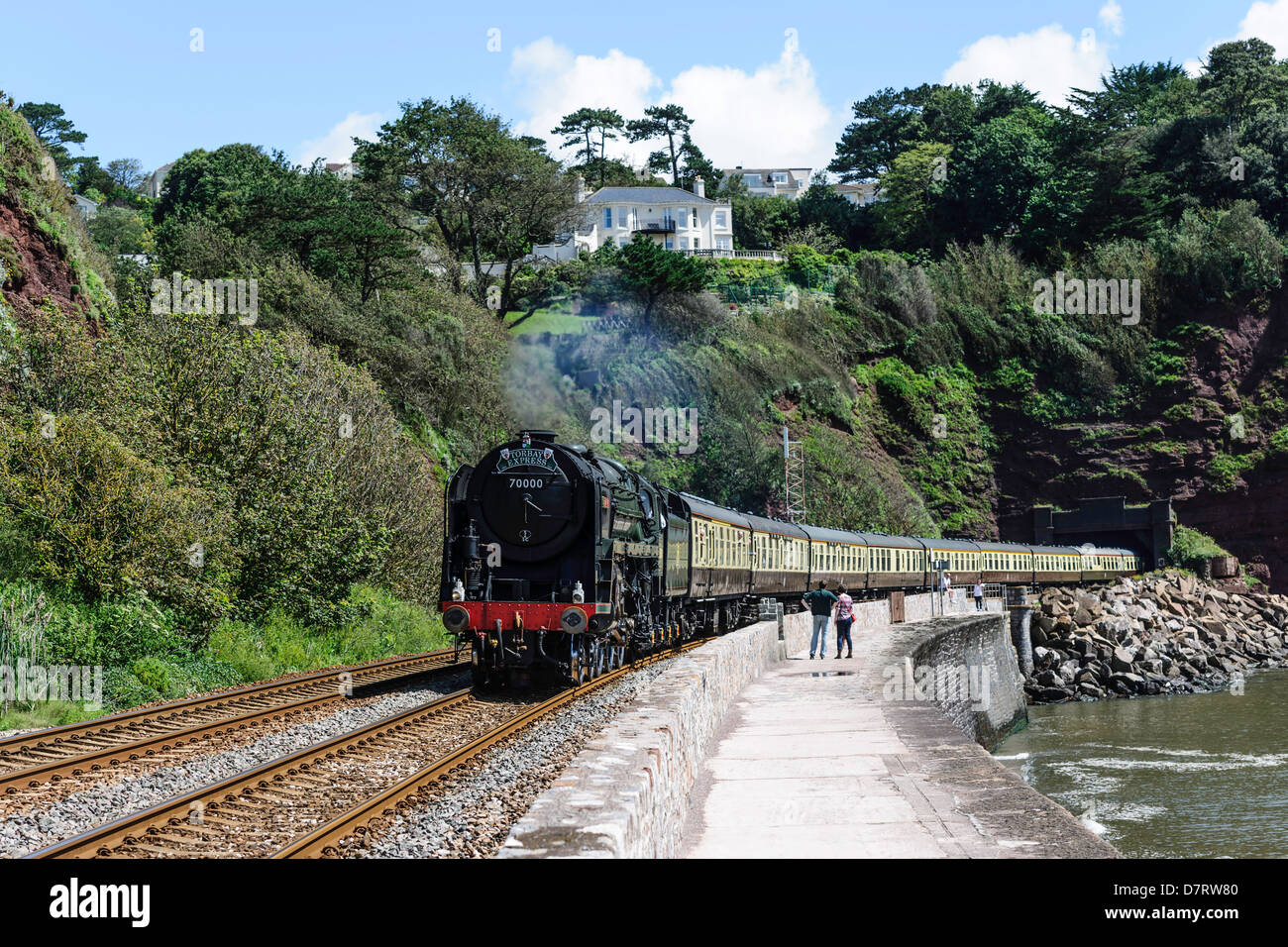 Die Torbay Express geschleppten Dampf Lok 70000 Britannia neben der Ufermauer Teignmouth South Devon UK. Stockfoto