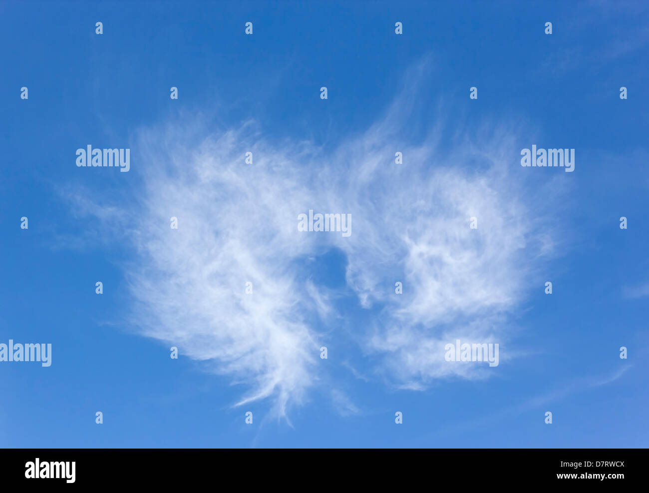 Weiße Wolke in der Form eines Herzens oder Engelsflügel in strahlend blauen Himmel. Stockfoto
