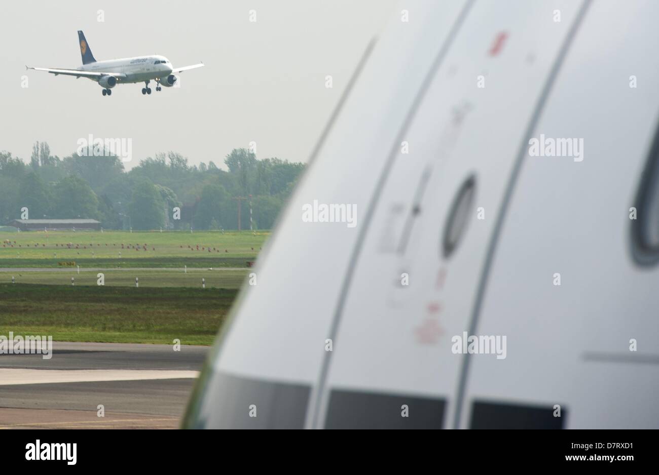 Ein Airbus der Fluggesellschaft Lufthansa befindet sich auf dem Landeanflug auf dem Flughafen Tegel in Berlin, Deutschland, 8. Mai 2013. In der Foregorund ein Airbus A 340-300 wartet auf Start. Foto: Soeren Stache Stockfoto