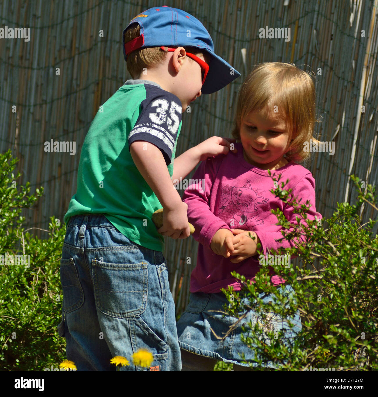 4 Jahre alten Kind und 2 Jahre alten Mädchen spielen auf dem Hinterhof Stockfoto