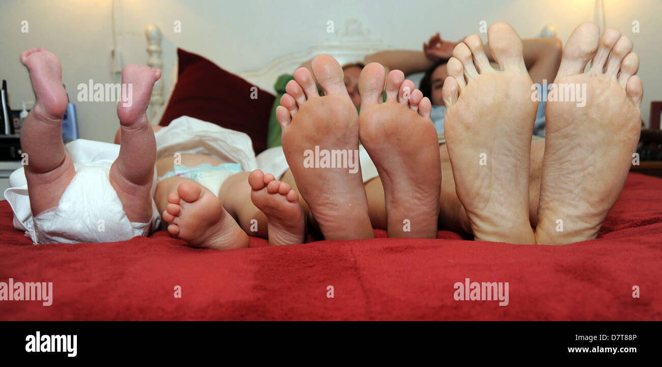 Familie Füße, Erwachsenenfüße, Kinderfüße, Fuß viele Füße, Zehen, von einem Bett, Füße auf ein Bett, viele der Zehe, Füße, Zehen, Fuß, Ende des Bettes, Stockfoto