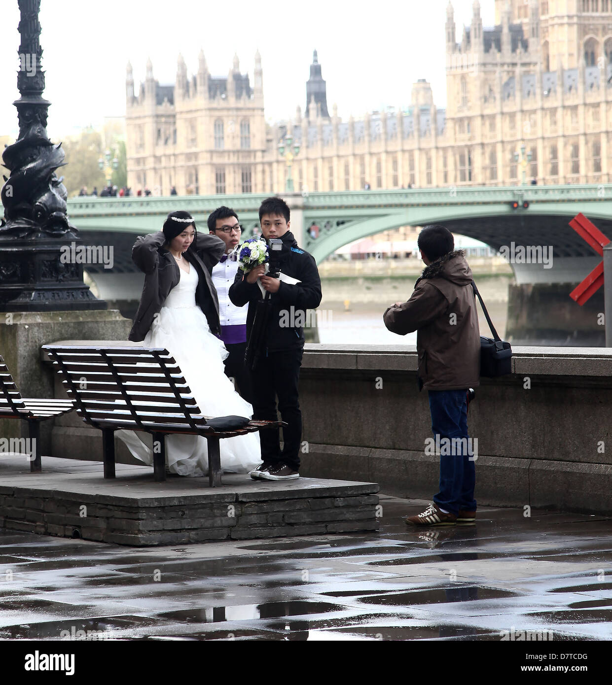 Frisch verheiratet japanisches Ehepaar mit ihrem Fotografen nach posiert vor The Houses of Parliament. Mai 2013 Stockfoto