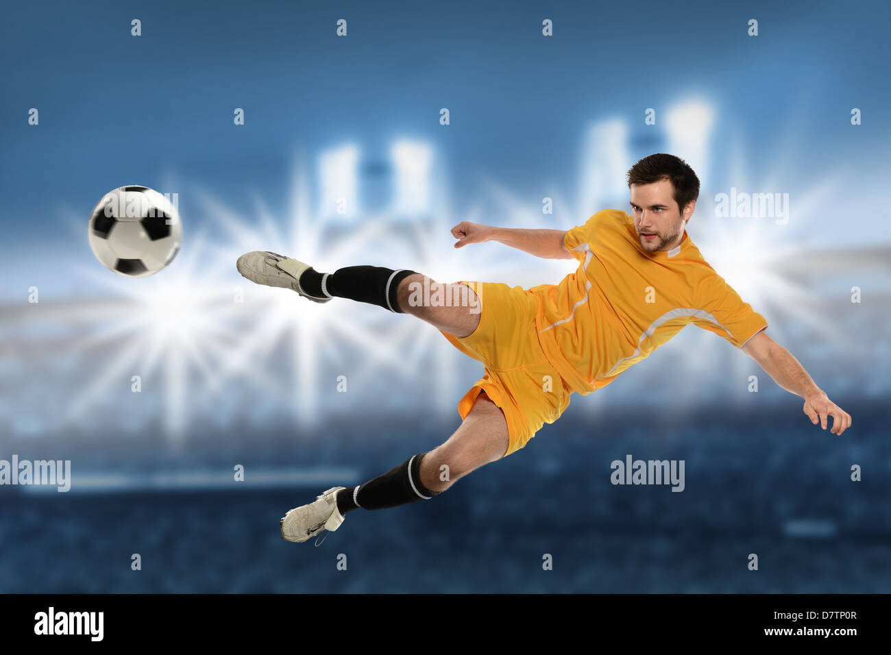 Fußballspieler in Aktion treten Ball über Stadion-Hintergrund Stockfoto