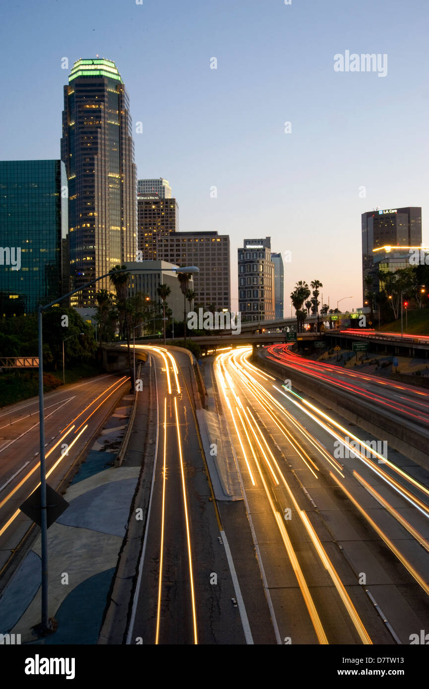 Die Scheinwerfer streiften in der Dämmerung auf der Autobahn durch Downtown Los Angeles, CA, USA Stockfoto