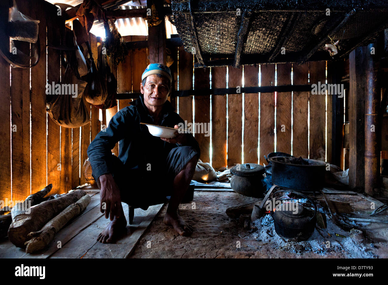 Animistischen Mann des Stammes Ann Essen in seinem Haus von offenem Feuer, Panlor Dorf, in der Nähe von Kengtung (Kyaingtong), Shan-Staat, Birma Stockfoto