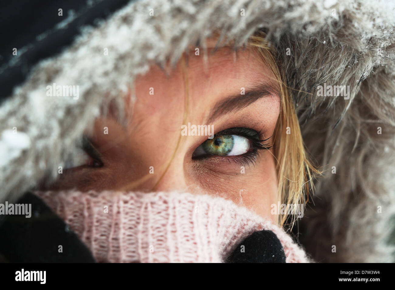 Schöne grüne Augen leuchten wie eine junge blonde Mädchen ist in einem kalten Winter Warm eingepackt Stockfoto