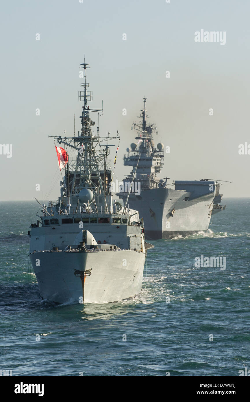 Kanadischen Zerstörer HMCS Iroquios führenden Royal Navy Angriff Träger HMS Illustrious auf See während einer Marineübung Stockfoto