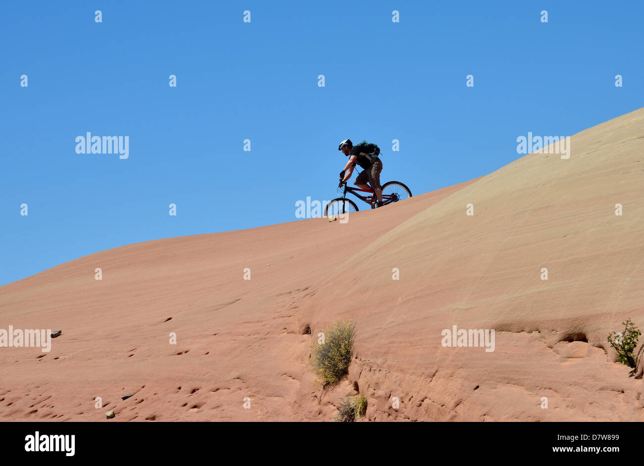 Ein Radfahrer auf einem Mountainbike auf rotem Sandstein. Moab, Utah, USA. Stockfoto