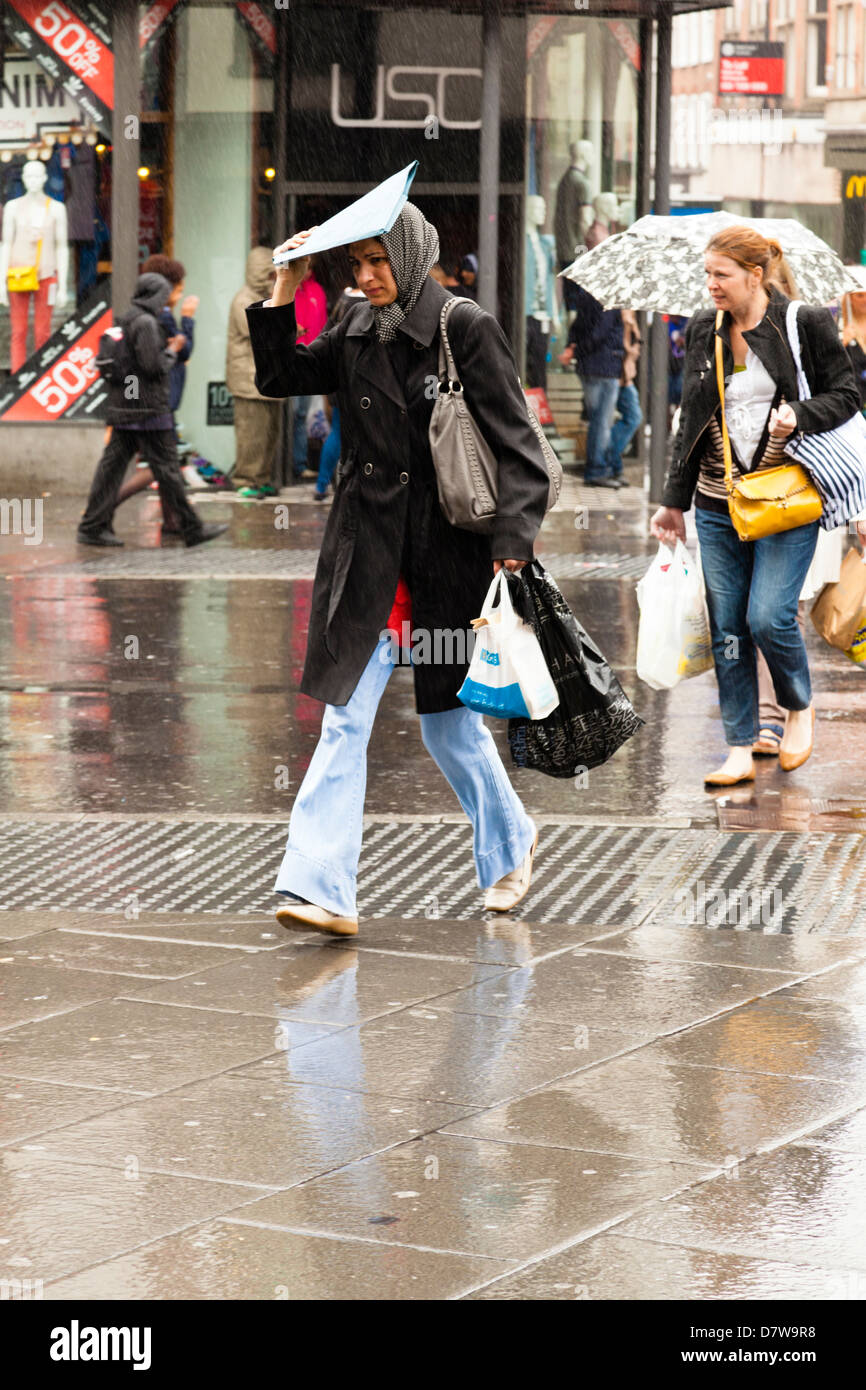 Frau, die ihren Kopf zu bedecken, bei einem Spaziergang durch Starkregen, Nottingham, England, UK Stockfoto