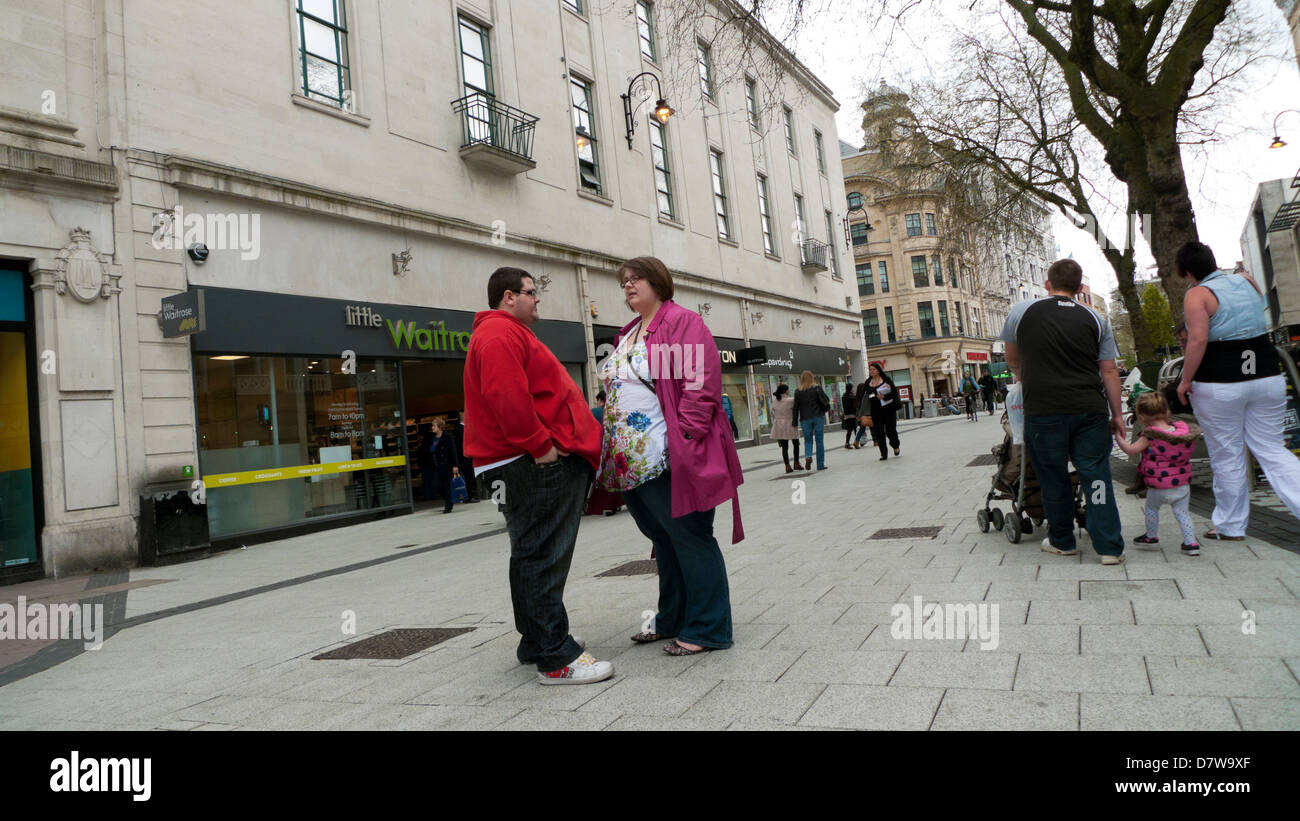 Übergewichtige junge Paar Leute auf der Straße sprechen, Großbritannien Stockfoto