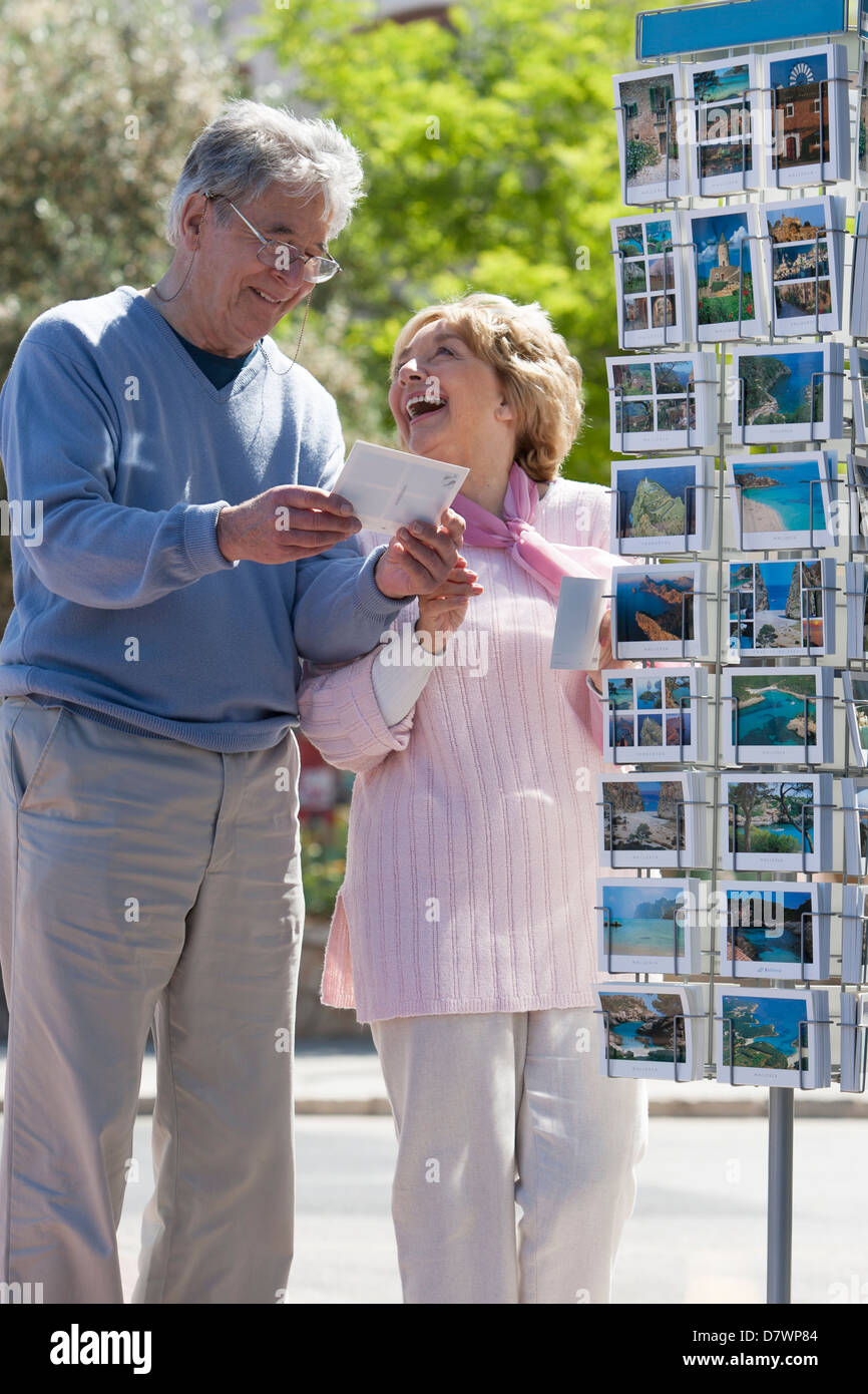 Älteres Ehepaar kaufen Postkarten im Urlaub Stockfoto