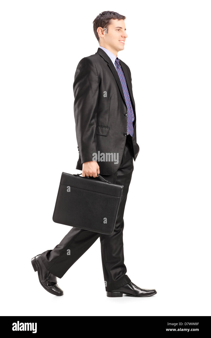 In voller Länge Portrait eines Geschäftsmannes zu Fuß und halten eine Aktentasche, isoliert auf weißem Hintergrund Stockfoto