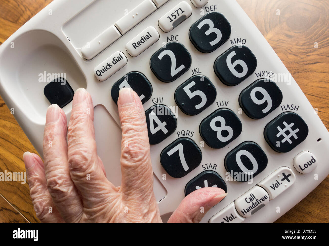 Ältere Dame mit Sehstörungen, die große Taste Telefon Nummer 1 anpressen Stockfoto