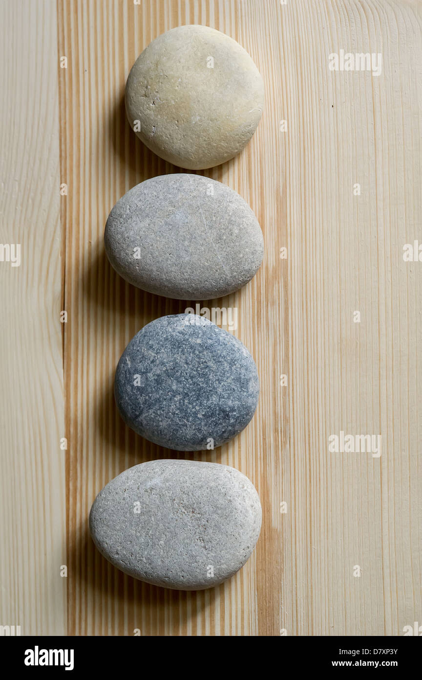 Spa Zen Steinen werden in einer Linie auf hellem Holz Hintergrund ausgerichtet. Stockfoto