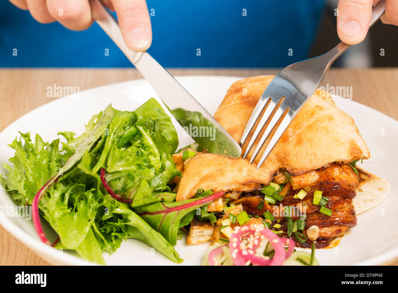 Pitta-Brot wird mit Messer schneiden Stockfoto