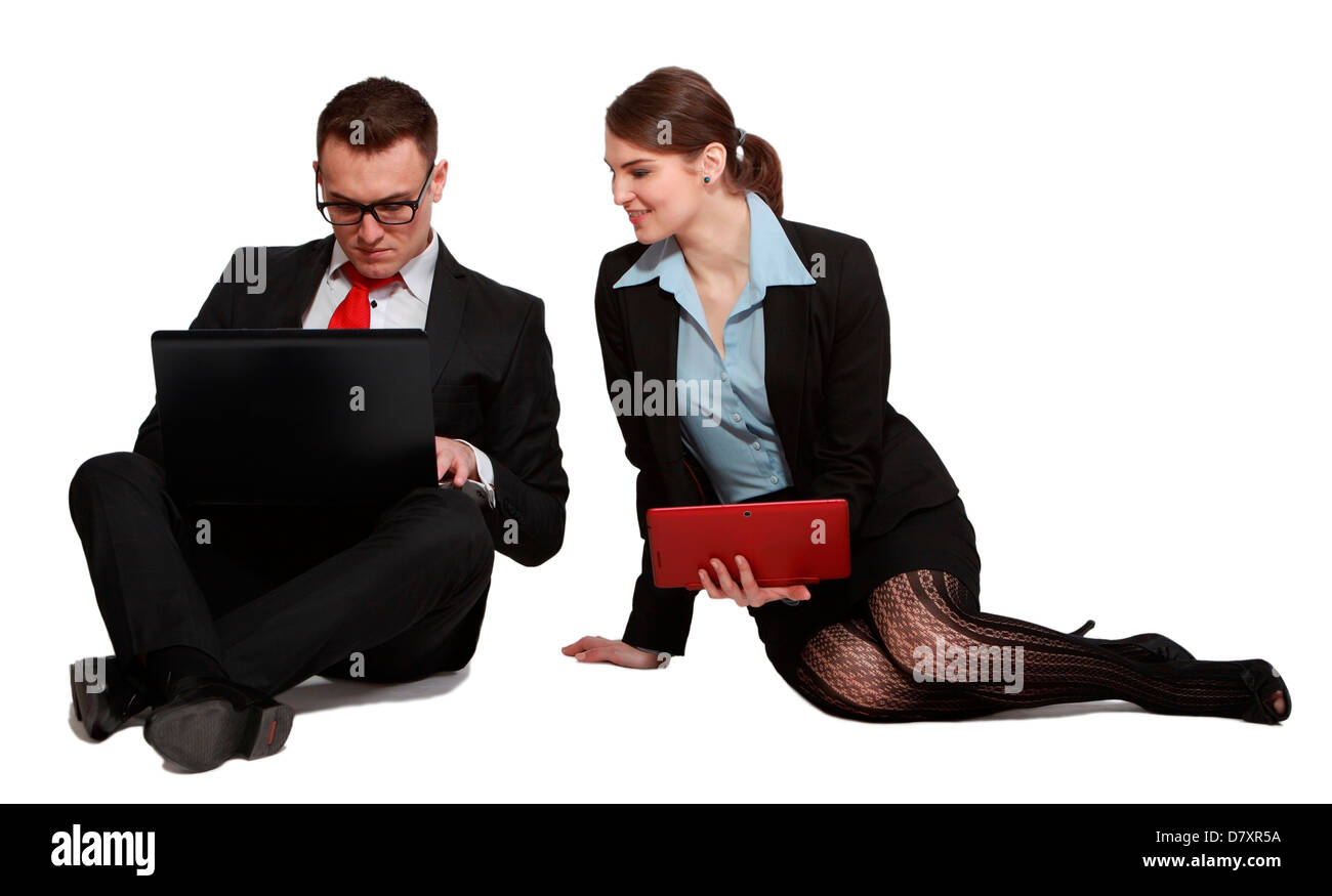 Junges Unternehmen paar teilen einander die Arbeit auf ihren Laptops beim Sitzen vor einem weißen Hintergrund. Stockfoto