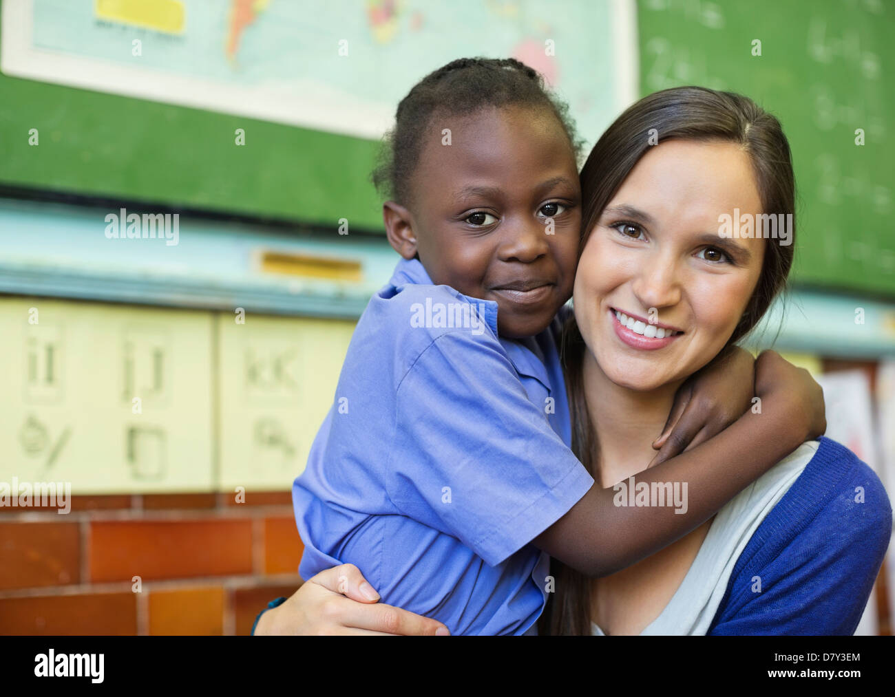 Lehrer umarmt Schüler in der Klasse Stockfoto